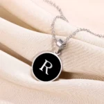 collier pendentif lettre en argent sur fond noir